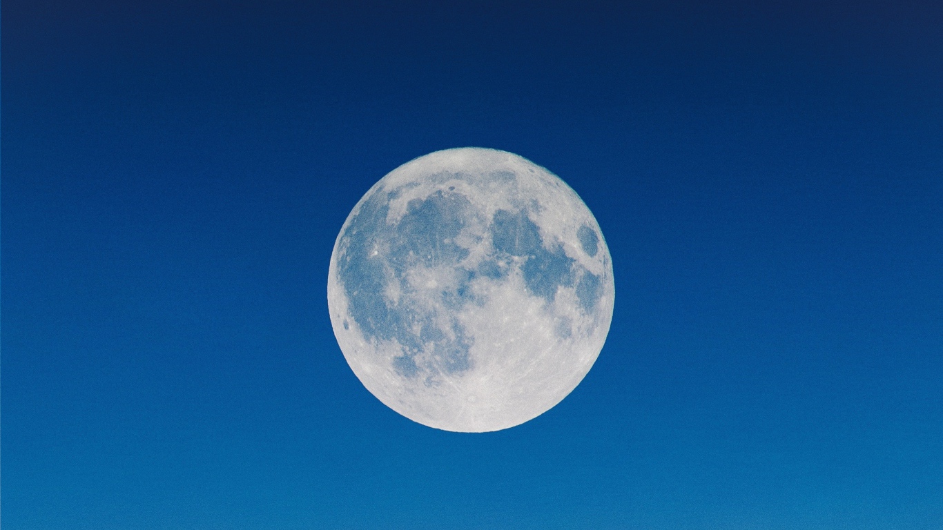 Большая белая луна в голубом небе
