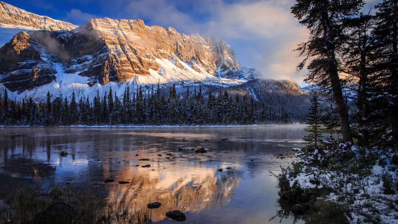 Покрытые снегом горы у заледеневшего озера