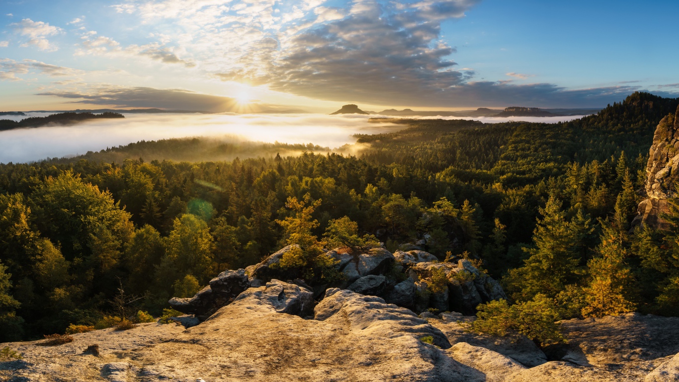 Вид со скалы на покрытый туманом лес и озеро на восходе солнца