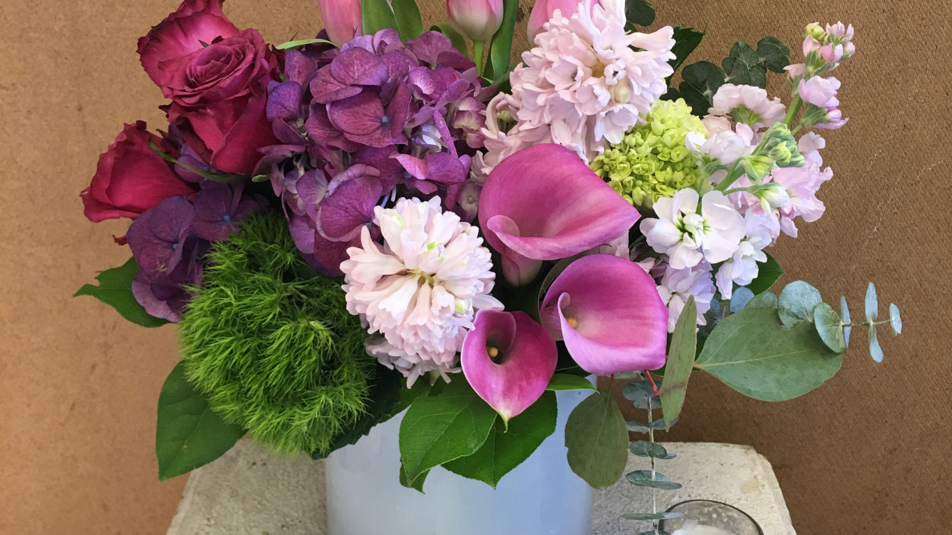 Красивый букет цветов в вазе у стены