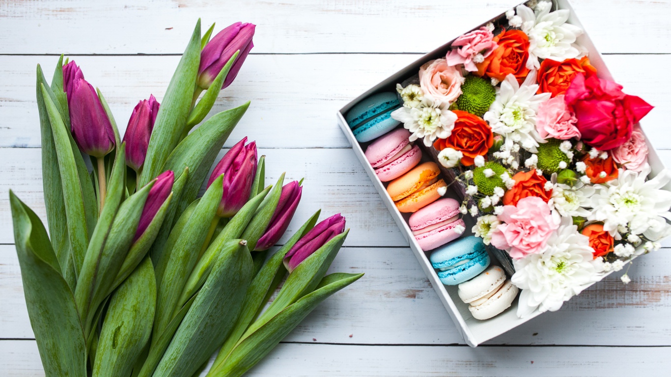 Букет сиреневых тюльпанов на столе с коробкой с макарунами