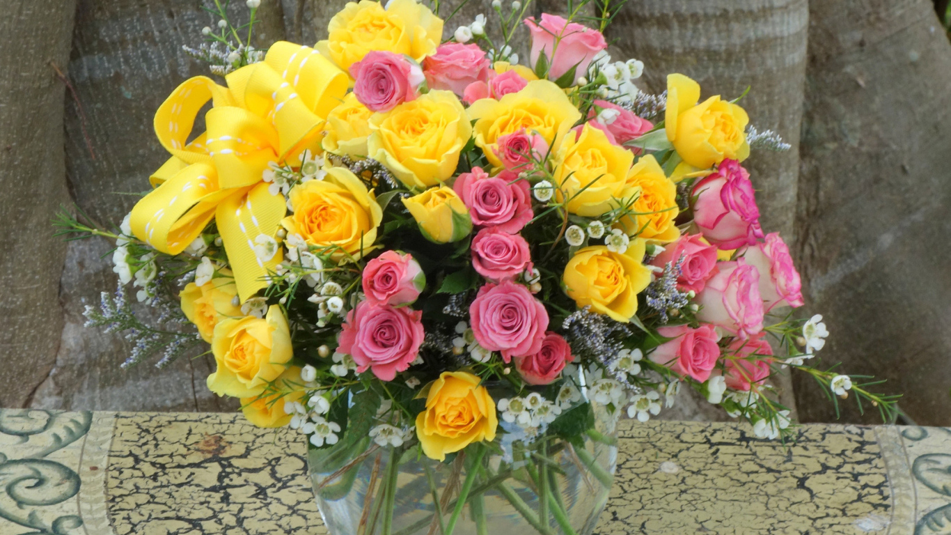 Букет желтых и розовых роз в стеклянной вазе