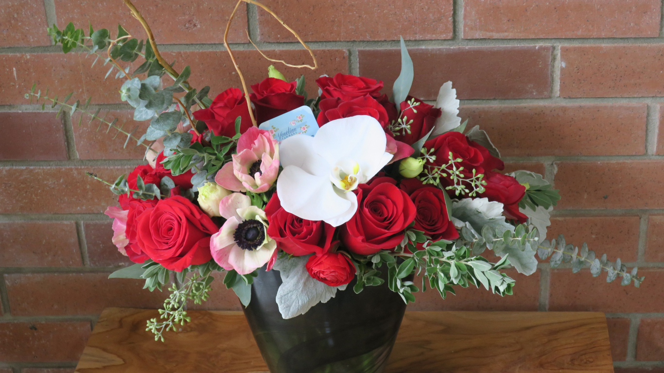 Букет с цветами анемоны, розы и орхидеи у стены 