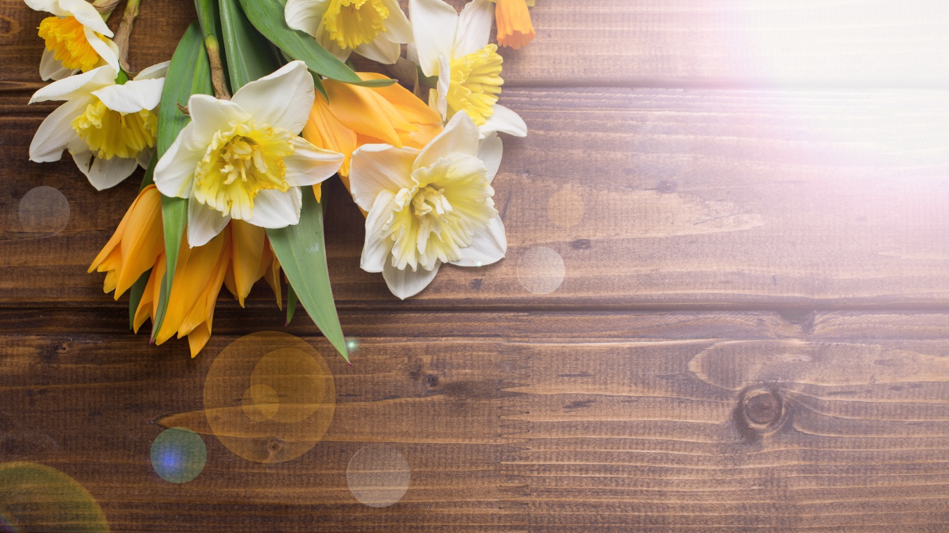 Нарциссы и желтые тюльпаны на деревянном фоне