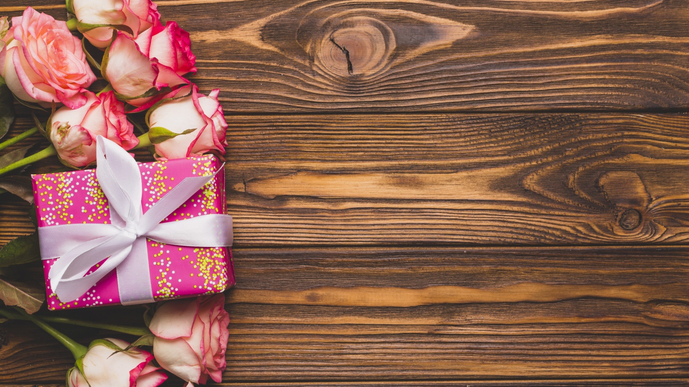 Подарочная коробка с букетом роз на деревянном фоне 