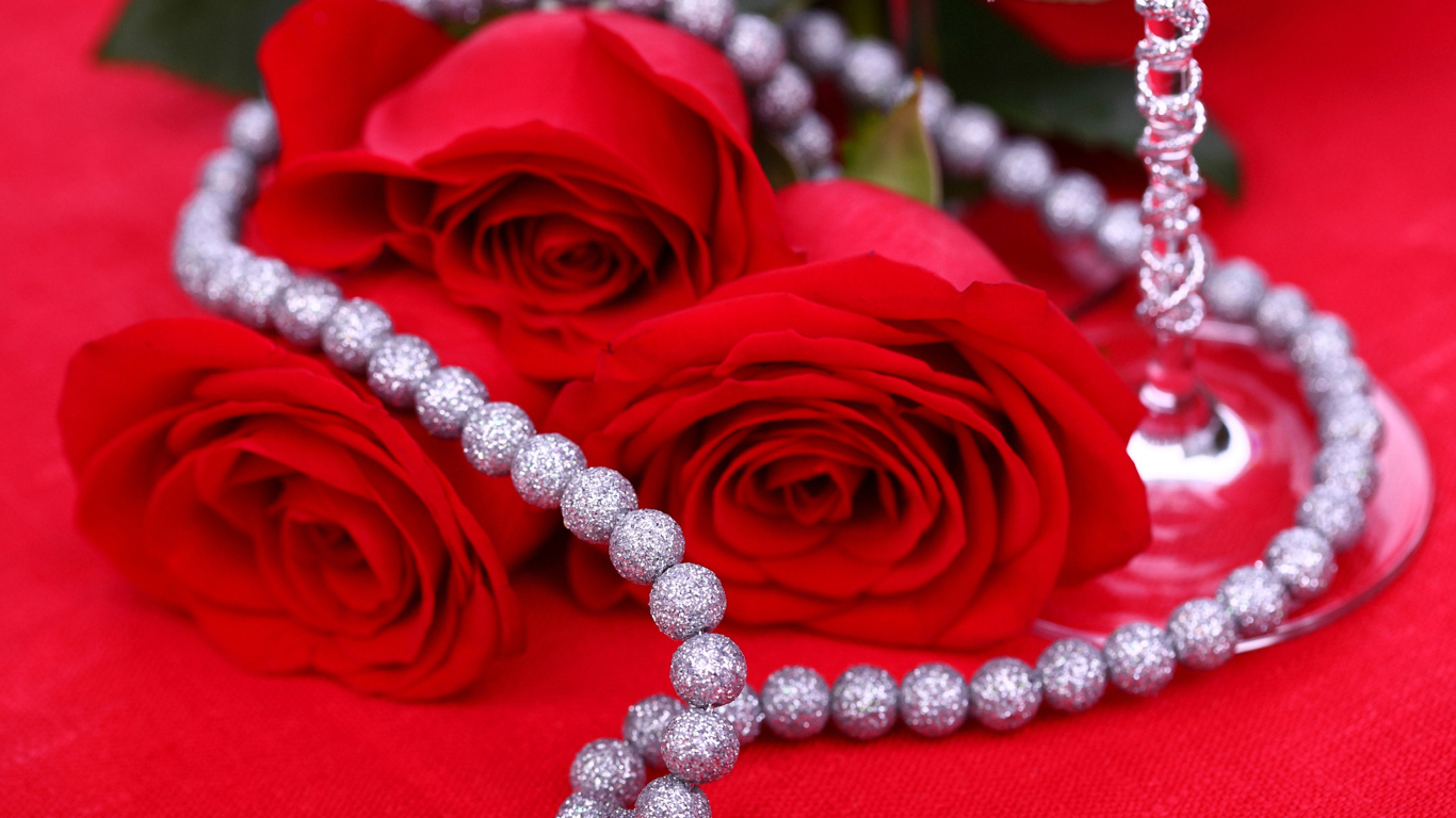 Три красные розы с украшением на красном фоне