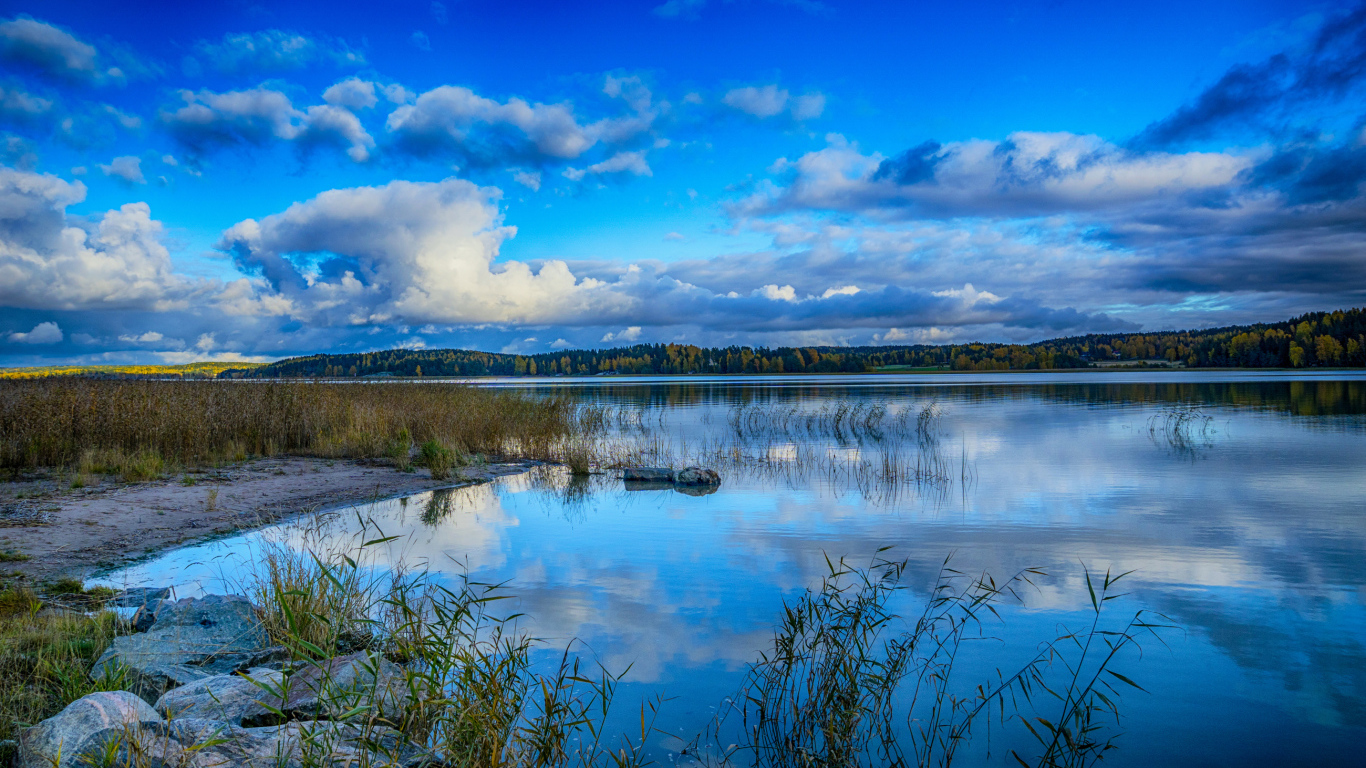 Голубое небо с облаками отражается в озере