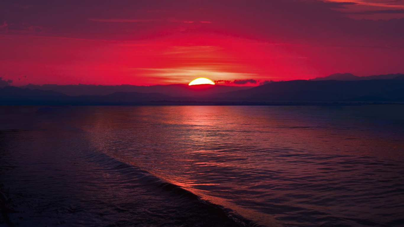 Закат красного солнца на морском горизонте 