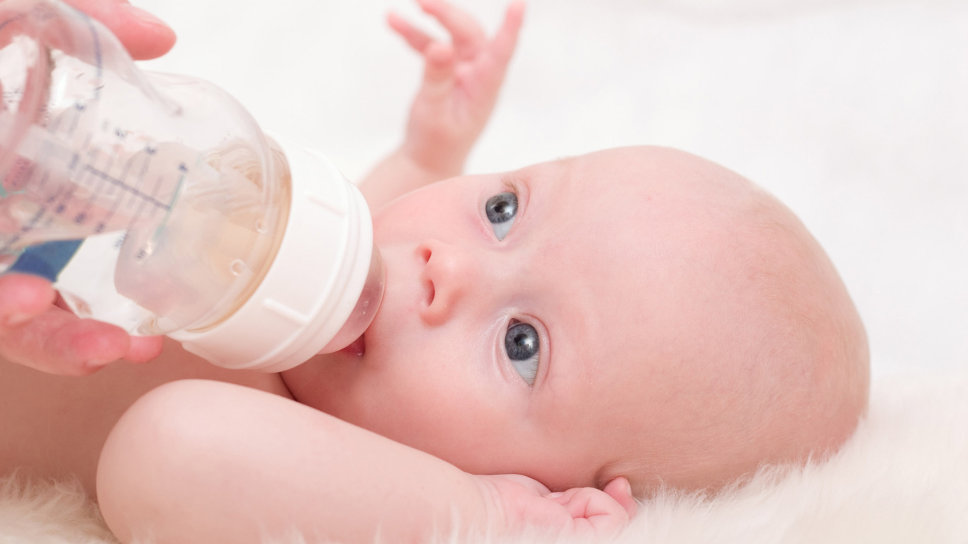 Новорожденного ребенка кормят с бутылки