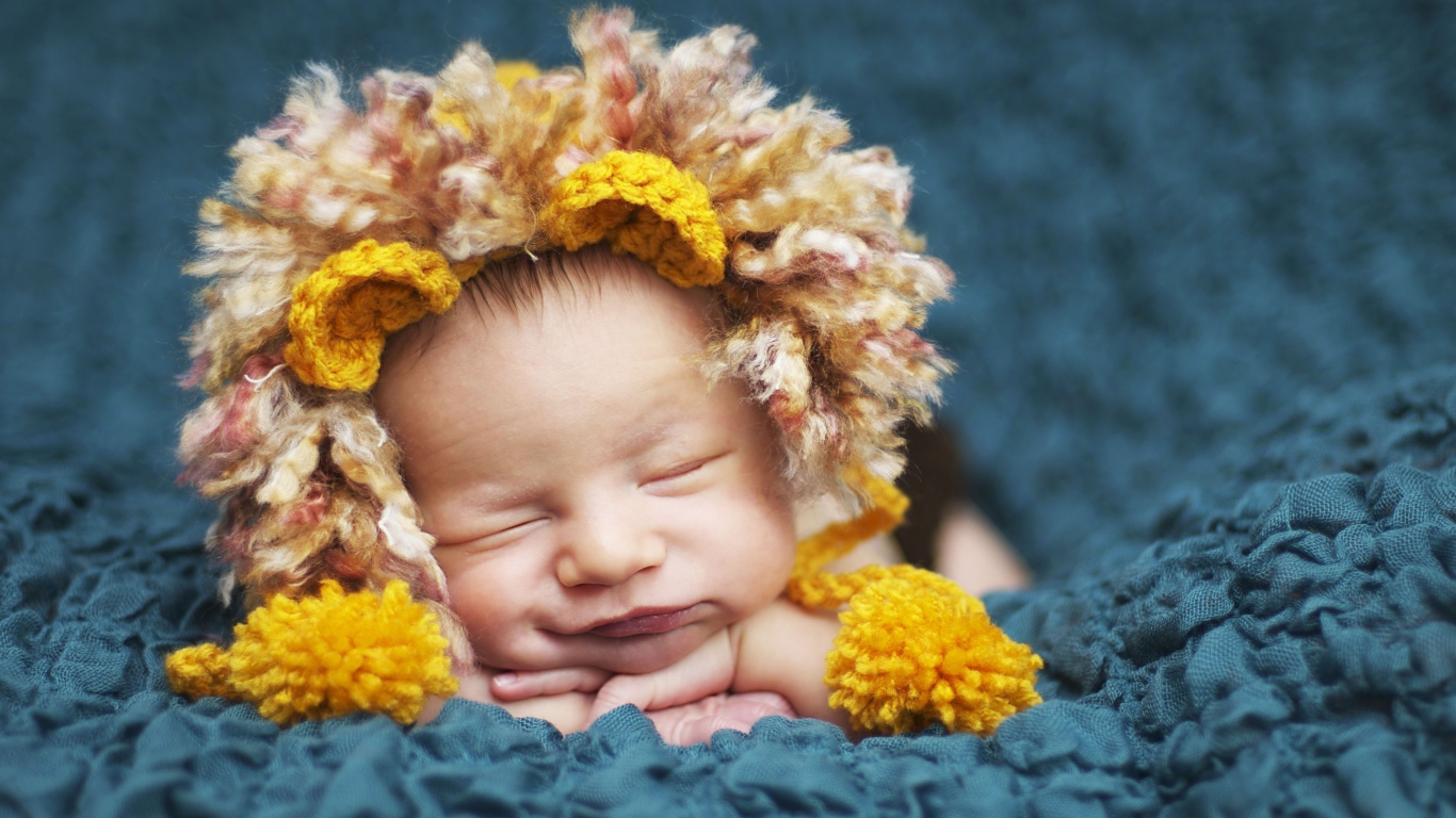 Милый спящий младенец в забавной шапке львенка