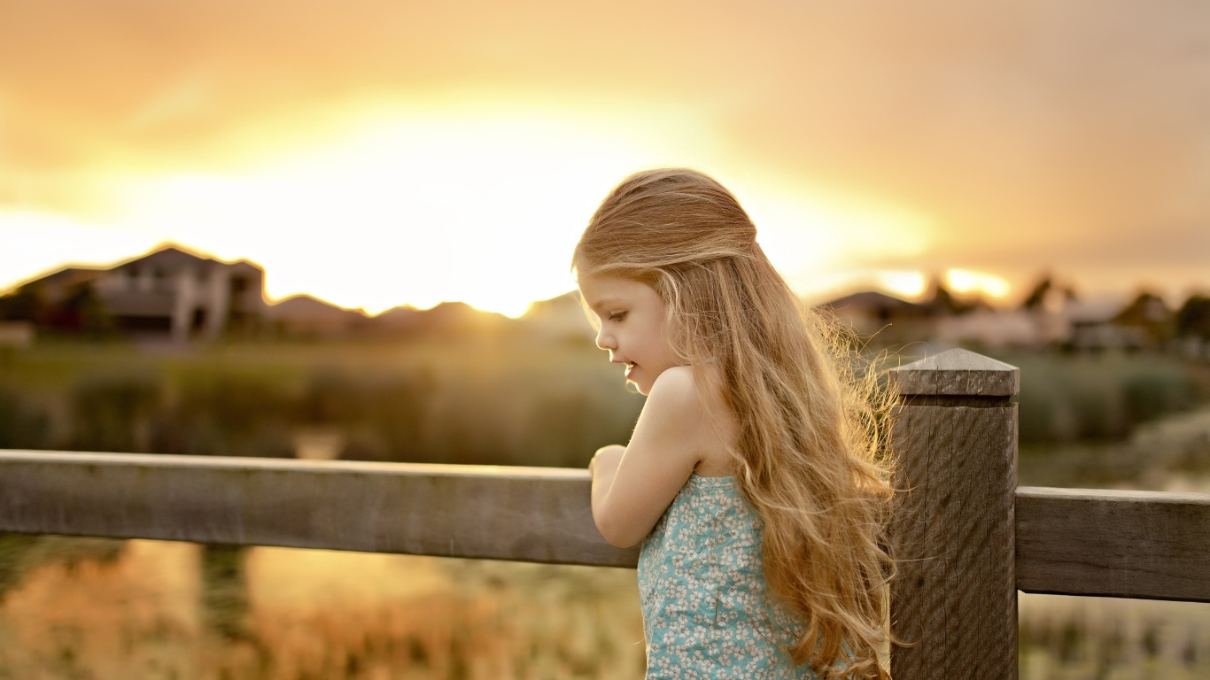 Красивая маленькая девочка на закате солнца