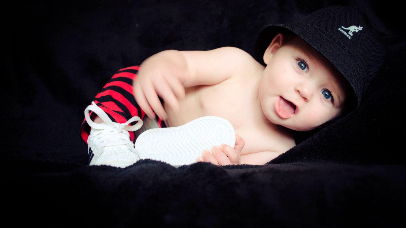 Забавный улыбающийся ребенок в черной панаме