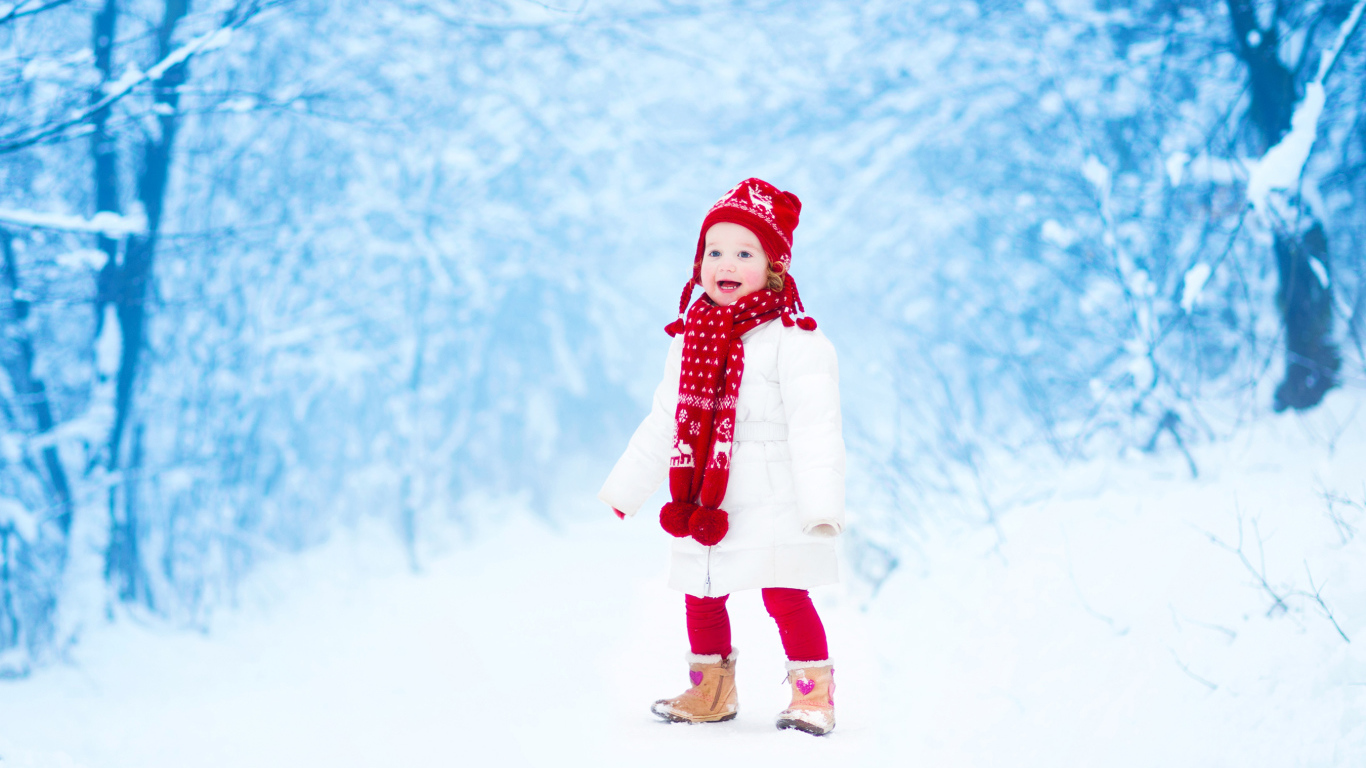 Маленькая веселая девочка в зимнем лесу