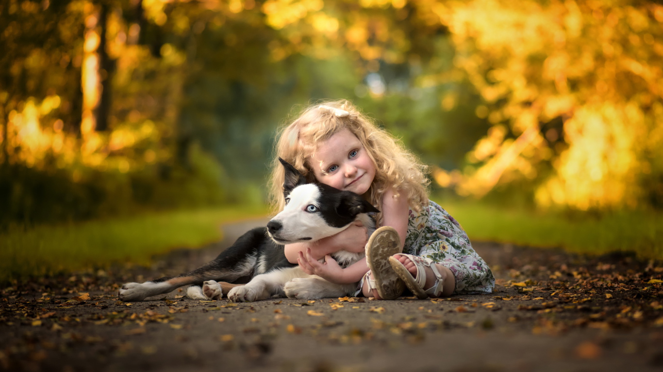 Маленькая милая девочка обнимает на дороге собаку