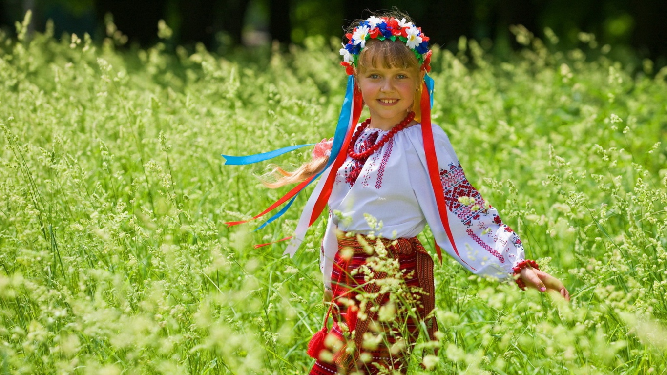 Маленькая девочка в костюме с венком на голове