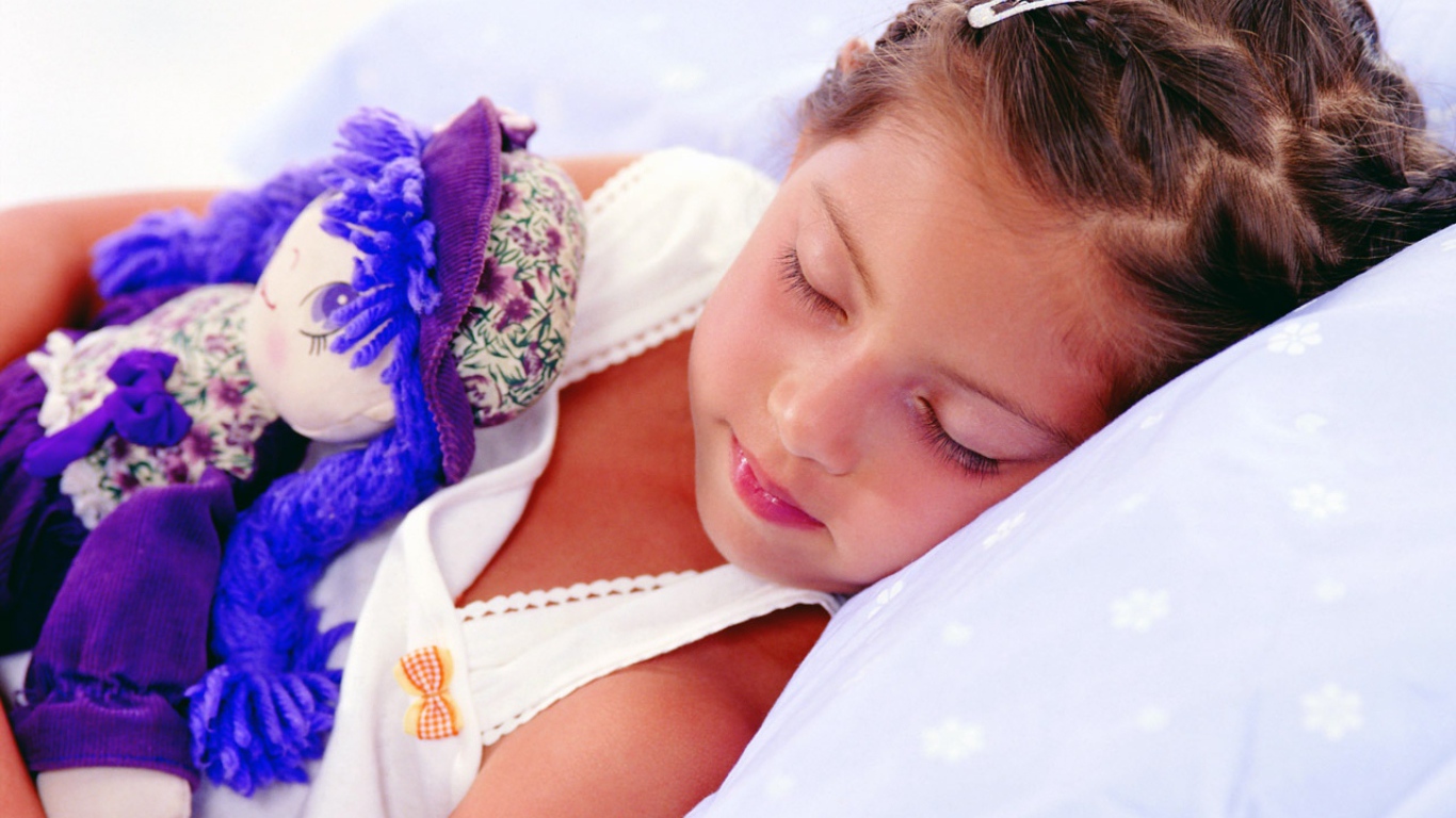 Маленькая девочка спит с игрушкой