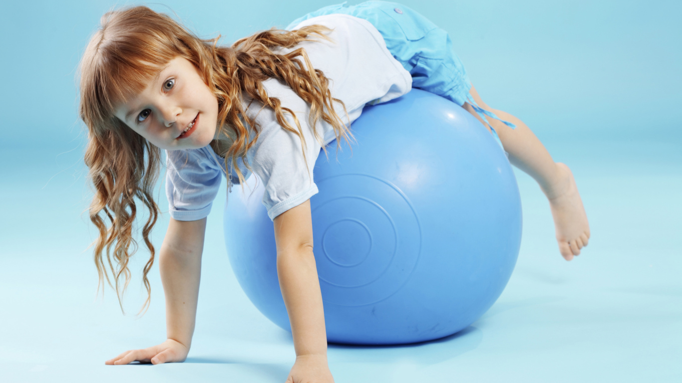 Маленькая девочка с большим голубым мячом