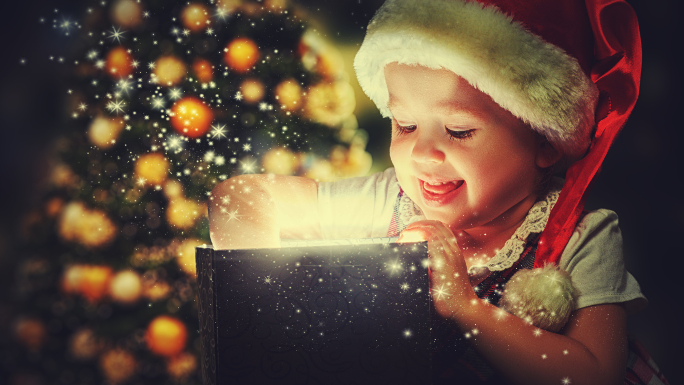 Маленькая улыбающаяся девочка открывает подарок у новогодней елки 