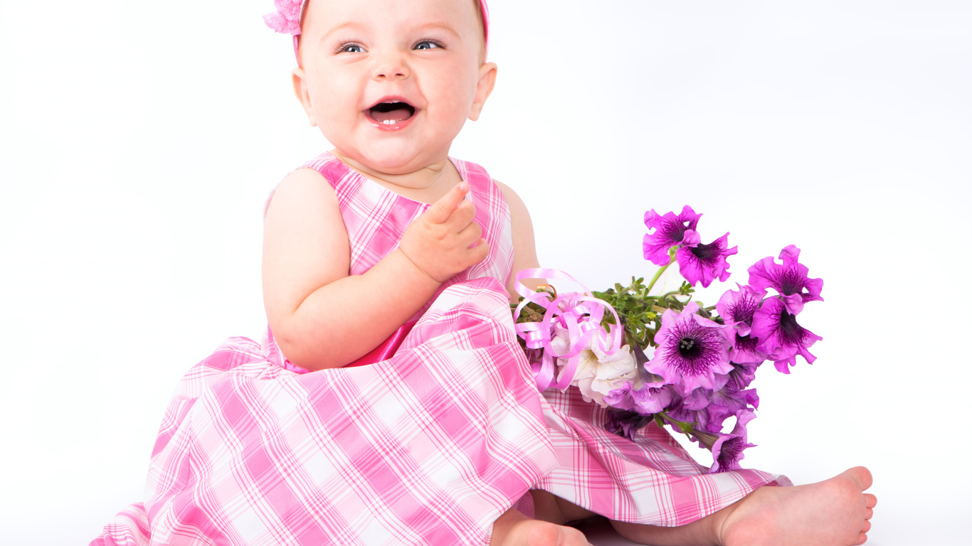 Маленькая улыбающаяся девочка с букетом петунии на белом фоне