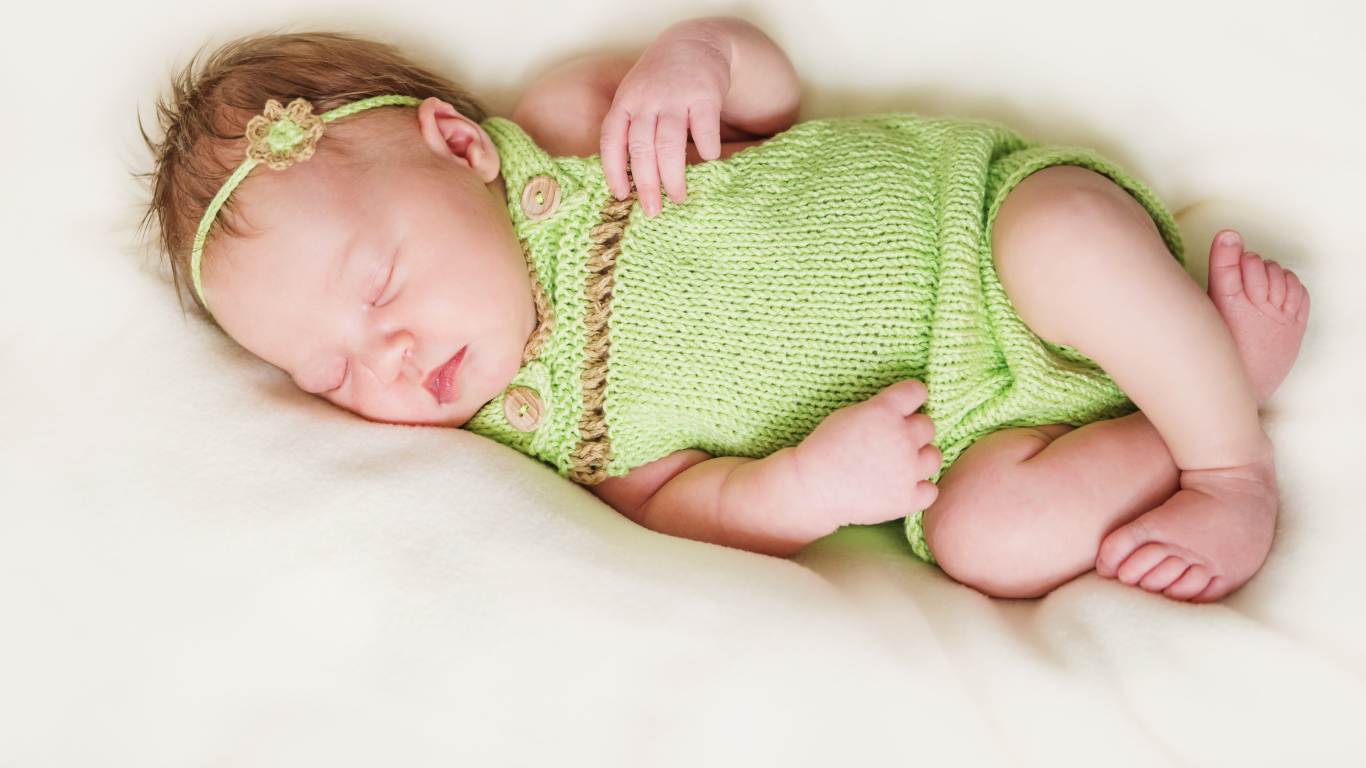 Спящий младенец в вязаной одежде