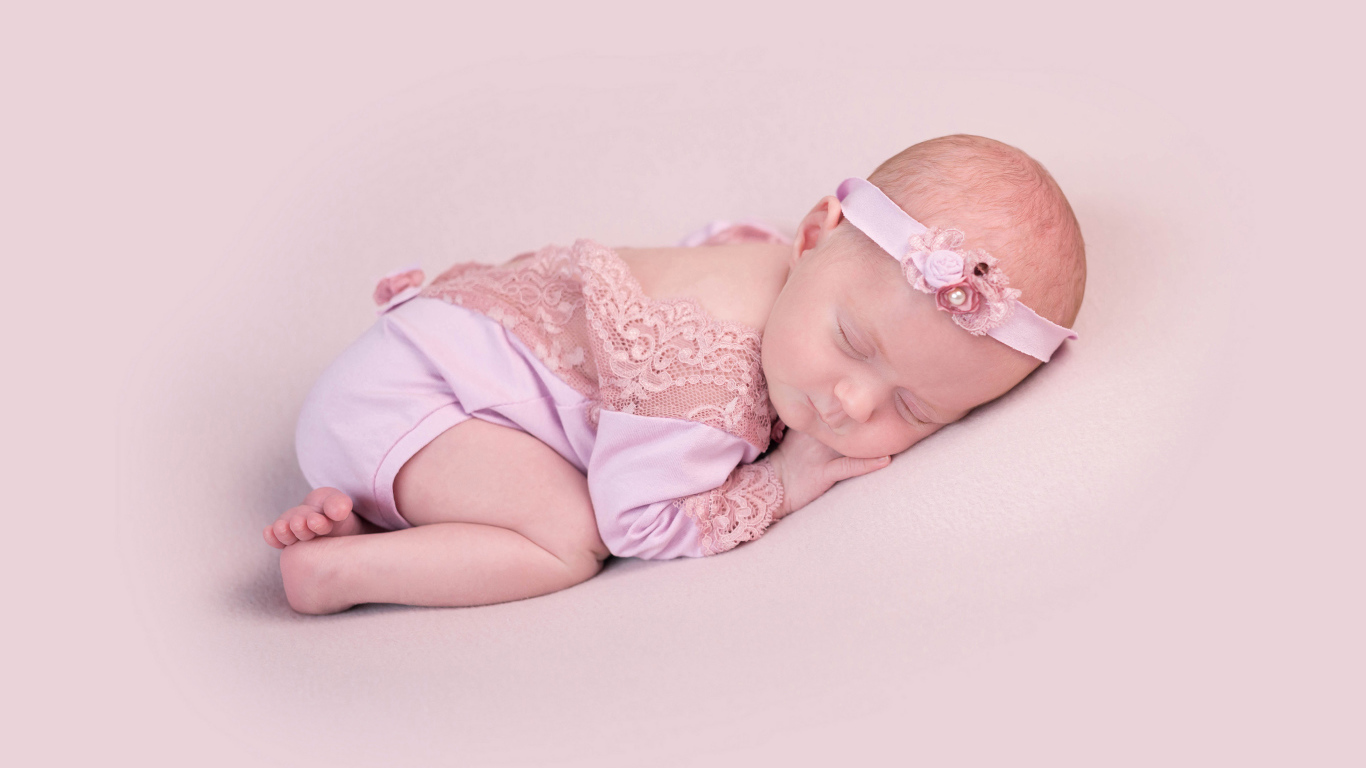 Спящий грудной ребенок на розовом фоне
