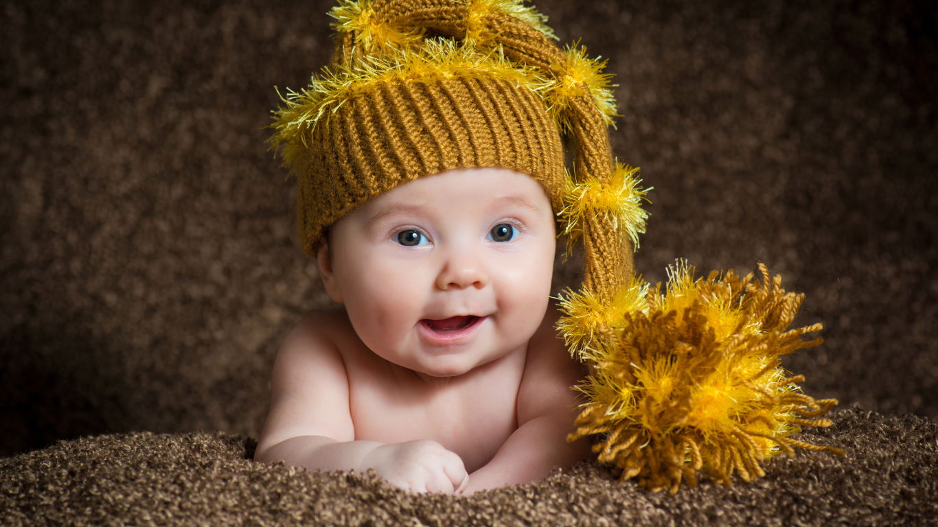 Улыбающийся малыш в красивой вязанной шапке 