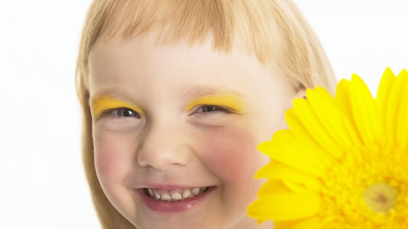 Улыбающаяся девочка с желтым цветком герберы