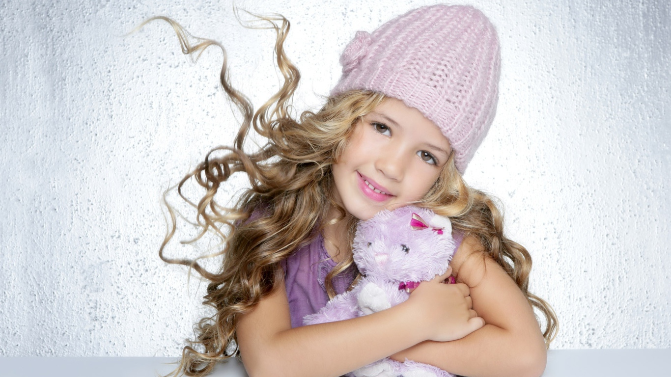 Милая светловолосая девочка с игрушкой