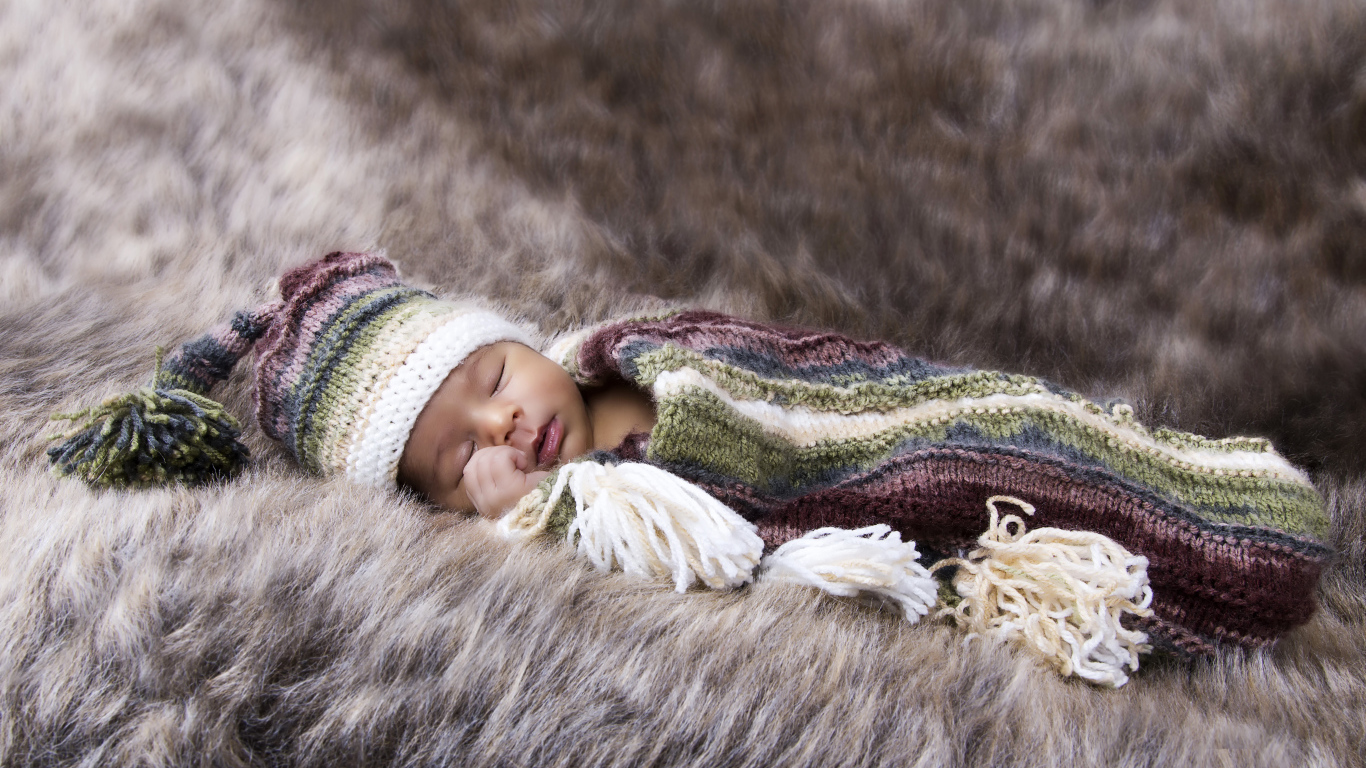 Младенец спит на меховом покрывале