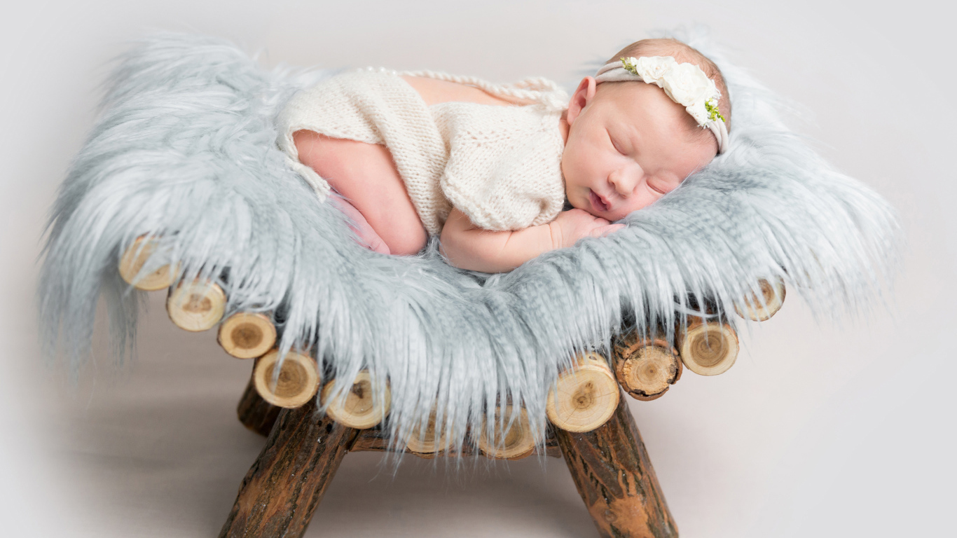 Грудной спящий ребенок лежит на деревянной кроватке