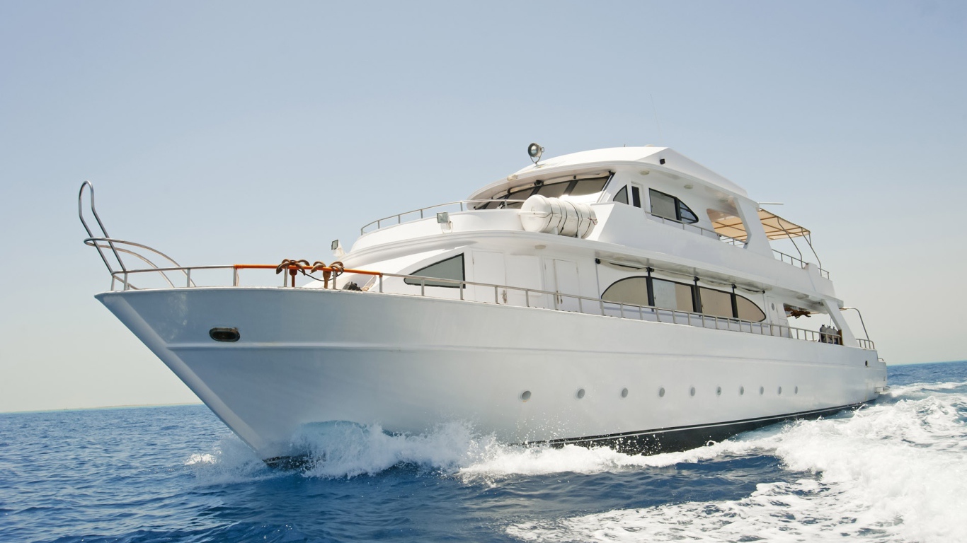 Красивая белая яхта в море на фоне голубого неба 