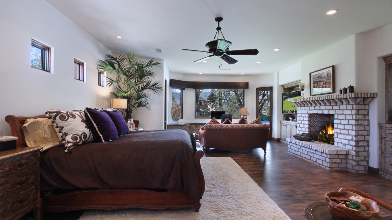 Спальная комната с большой кроватью с камином