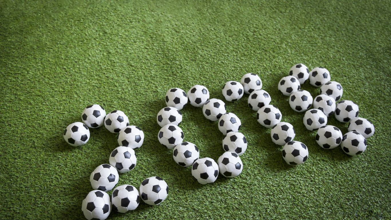 Цифры 2018 из футбольных мячей на зеленой траве