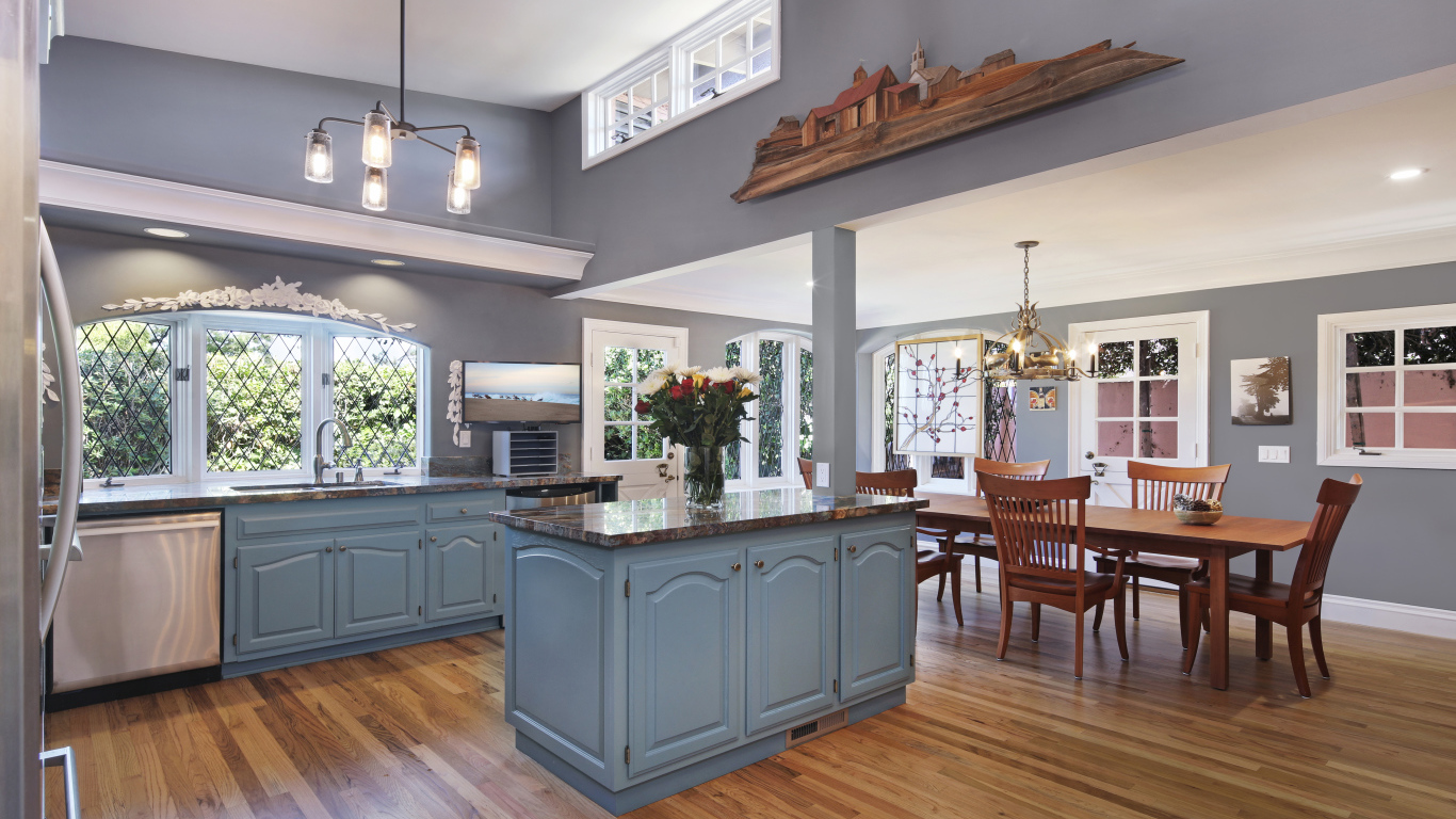 Большая красивая кухня в сером цвете с деревянным столом