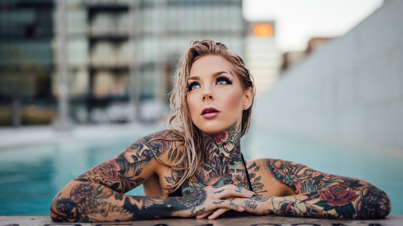Молодая девушка с красивыми татуировками на теле