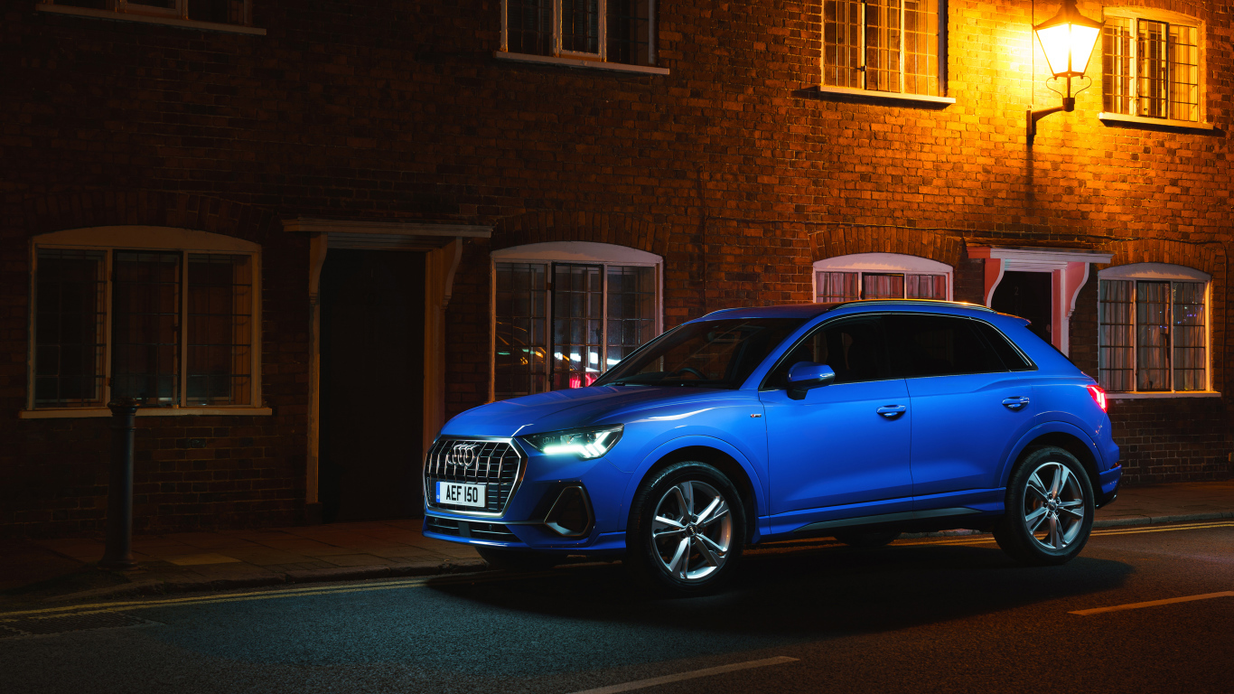 Blue Audi Q3 35 TFSI S Line car against the background of the building in the evening
