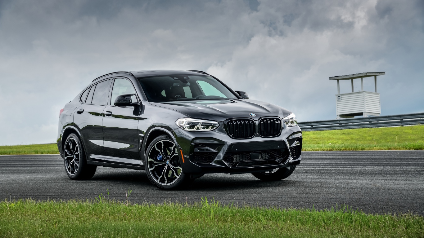 Черный автомобиль  BMW X4 M Competition, 2020 года на фоне грозового неба