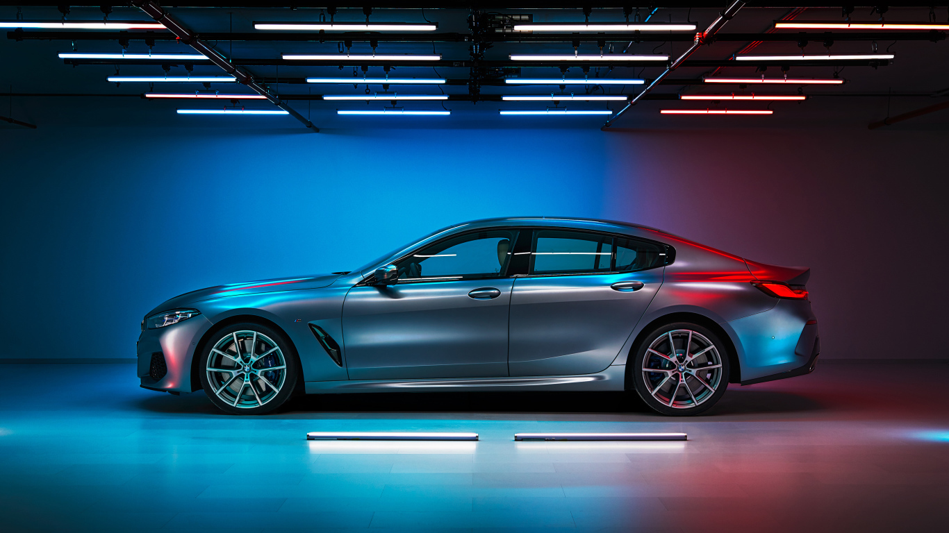 Серебристый автомобиль BMW M850i,  2019 года вид сбоку