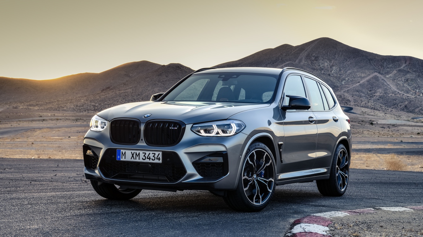 Серебристый автомобиль BMW X3  на асфальте
