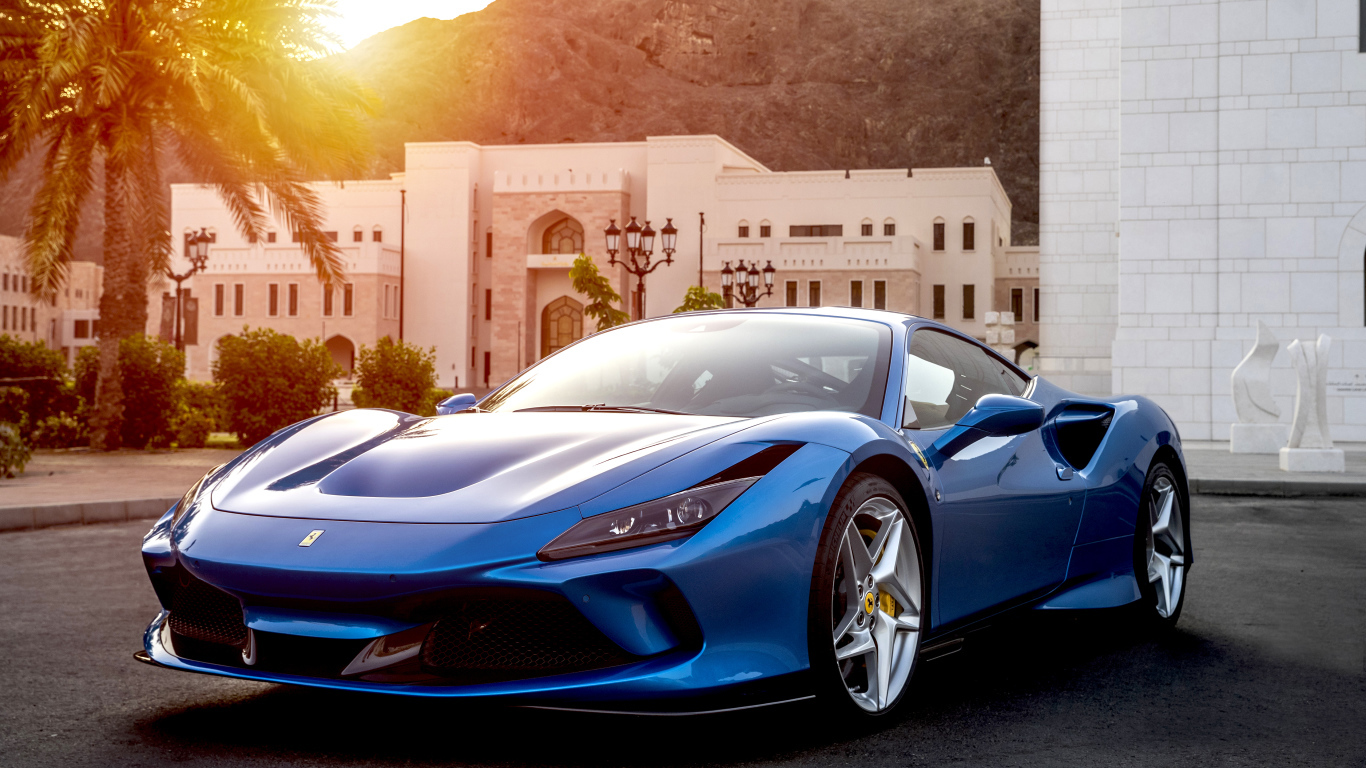 Голубой спортивный автомобиль Ferrari F8 Tributo 2019 года на фоне здания