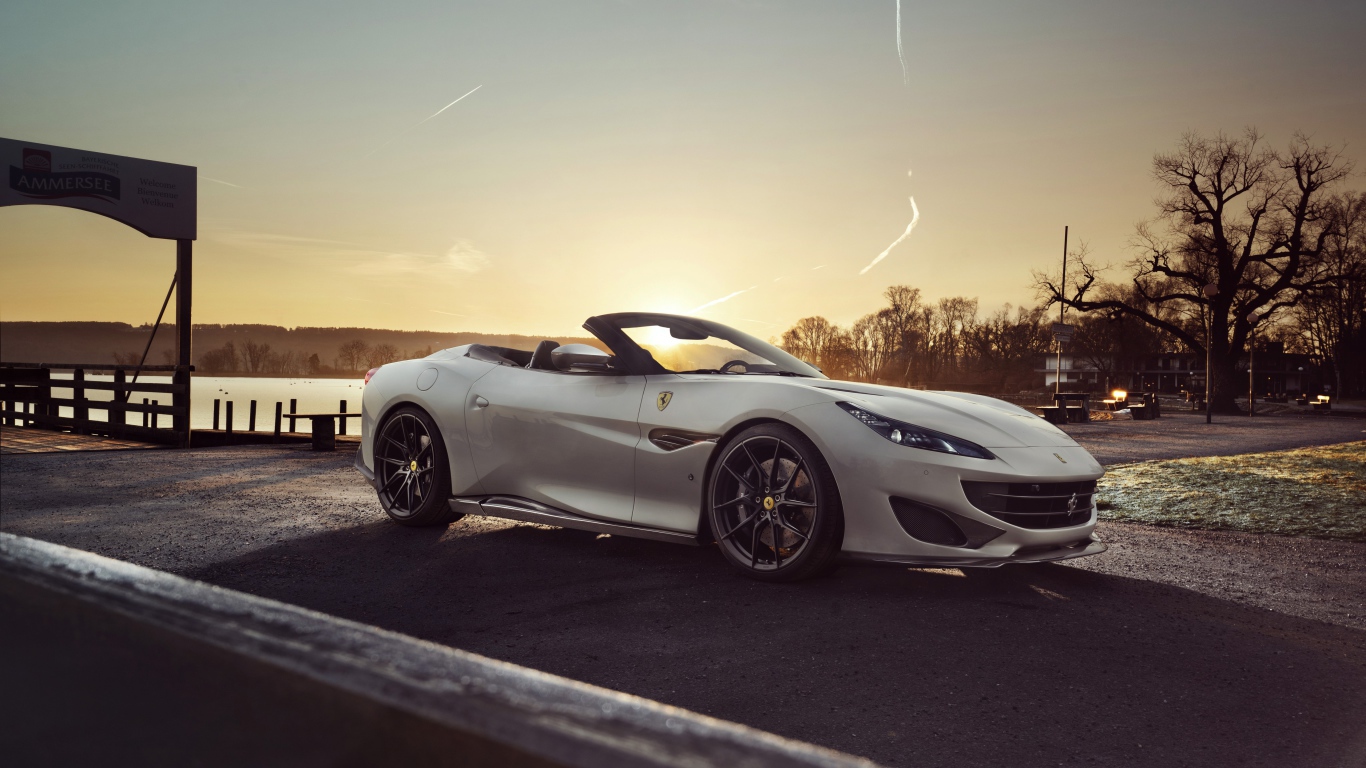 Серебристый кабриолет Ferrari Portofino 2019 года на фоне заката