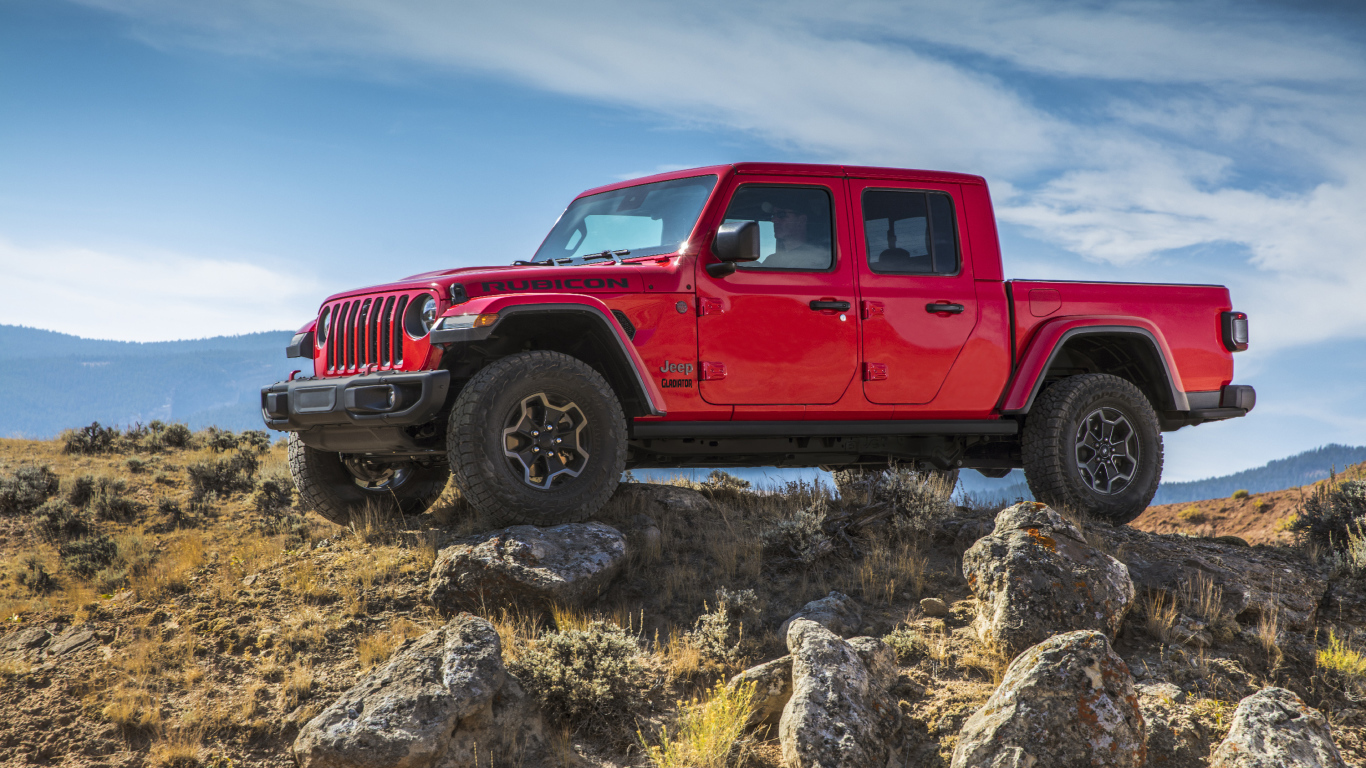 Красный пикап Jeep Gladiator Rubicon на холме с камнями