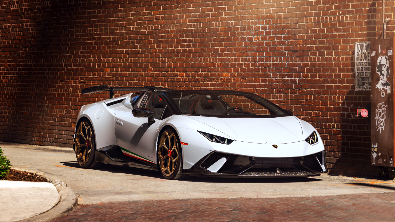 Белый быстрый Lamborghini Huracan стоит у кирпичной стены