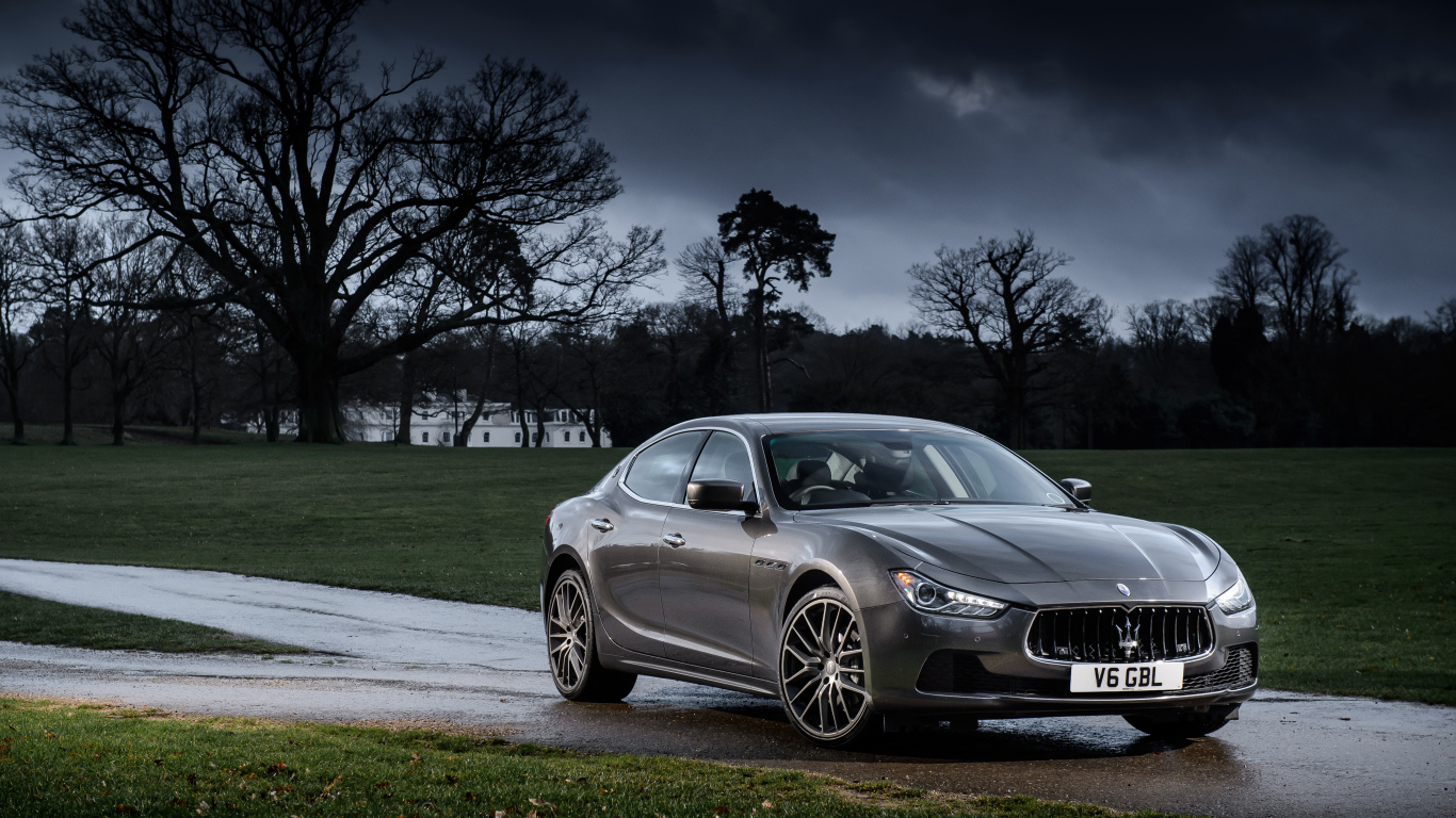 Серебристый автомобиль Maserati Ghibli на фоне грозового неба