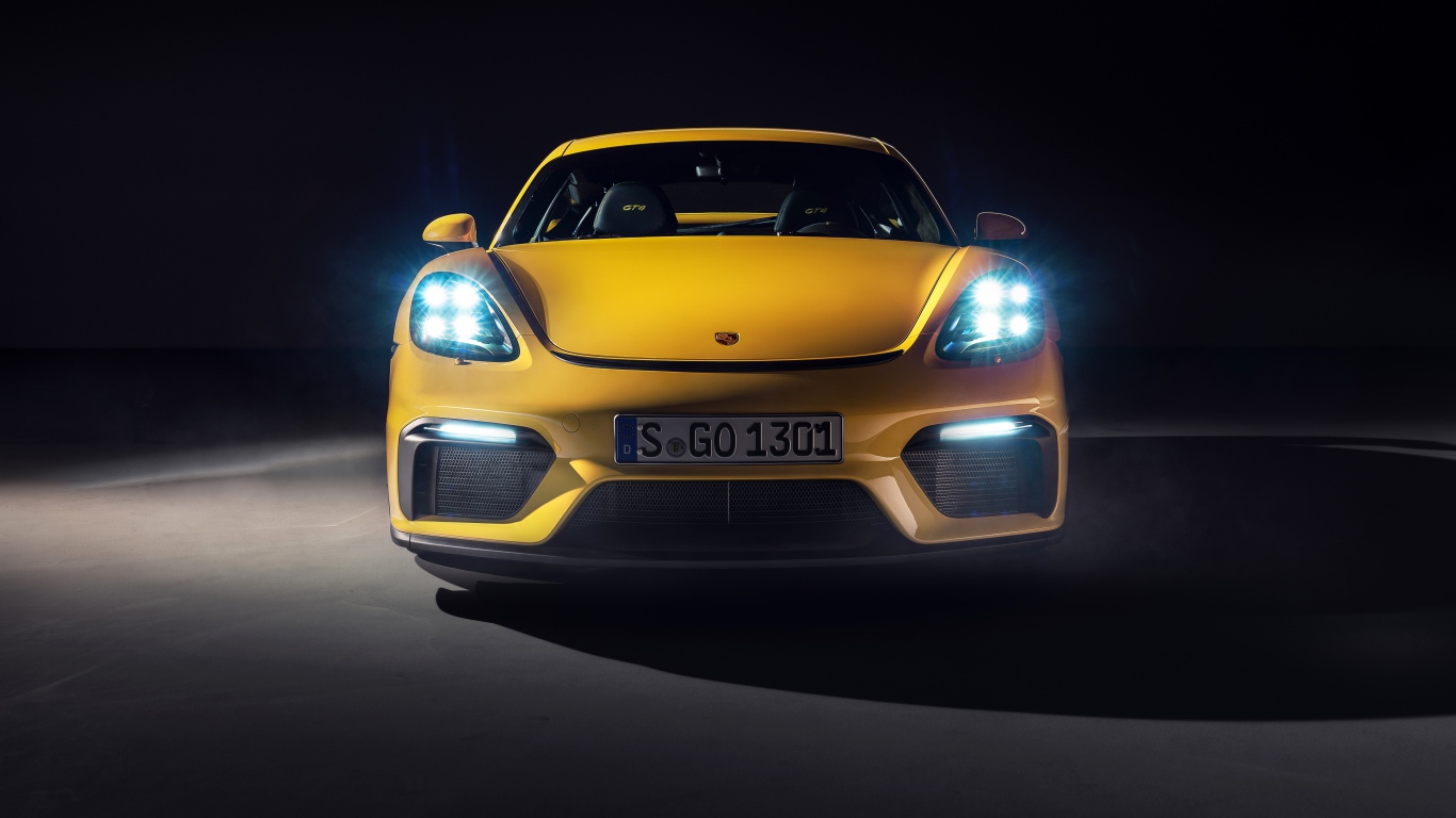 Автомобиль Porsche 718 Cayman GT4,  2019 года с включенными фарами 