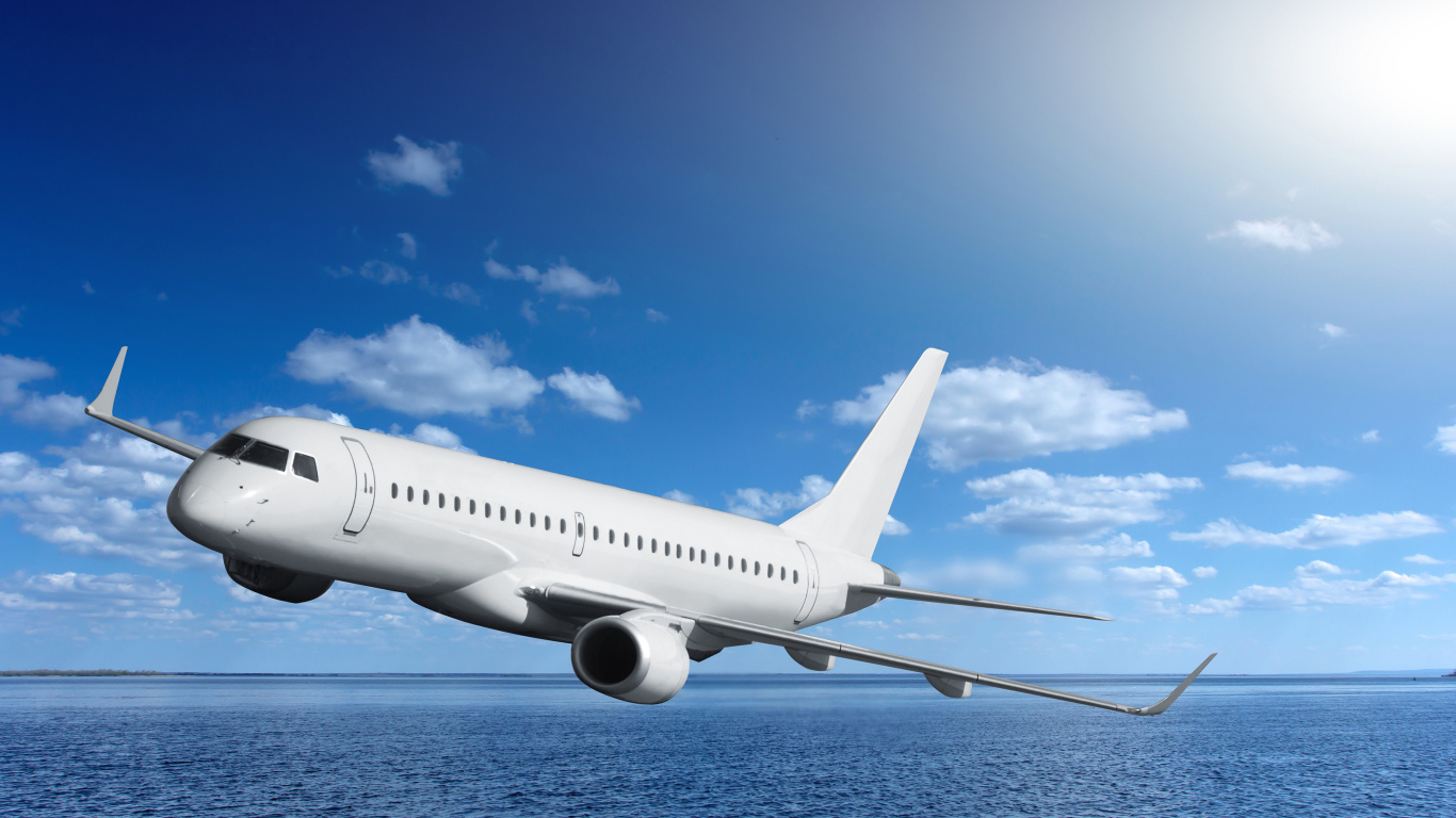 Большой белый пассажирский самолет летит над морем