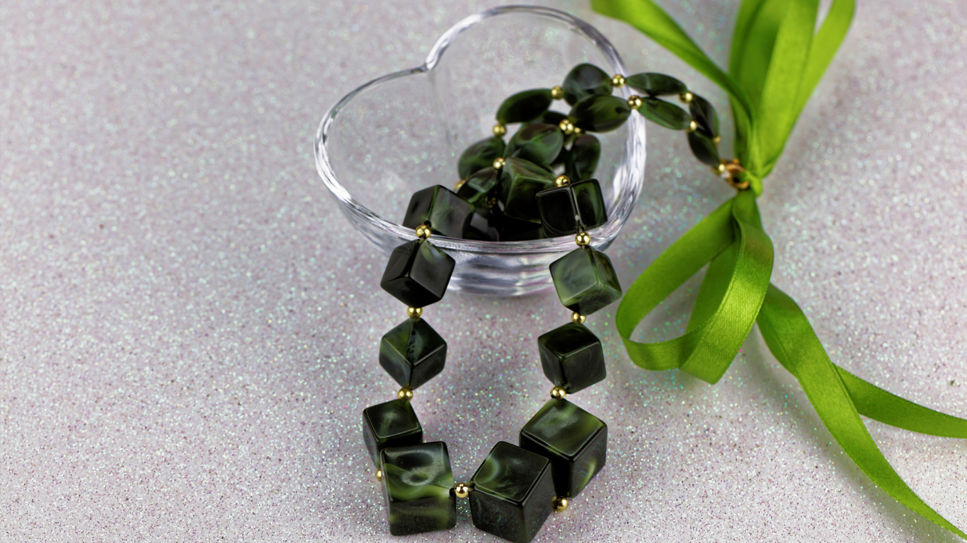 Ювелирное изделие с  бантиком в стеклянной вазочке на столе