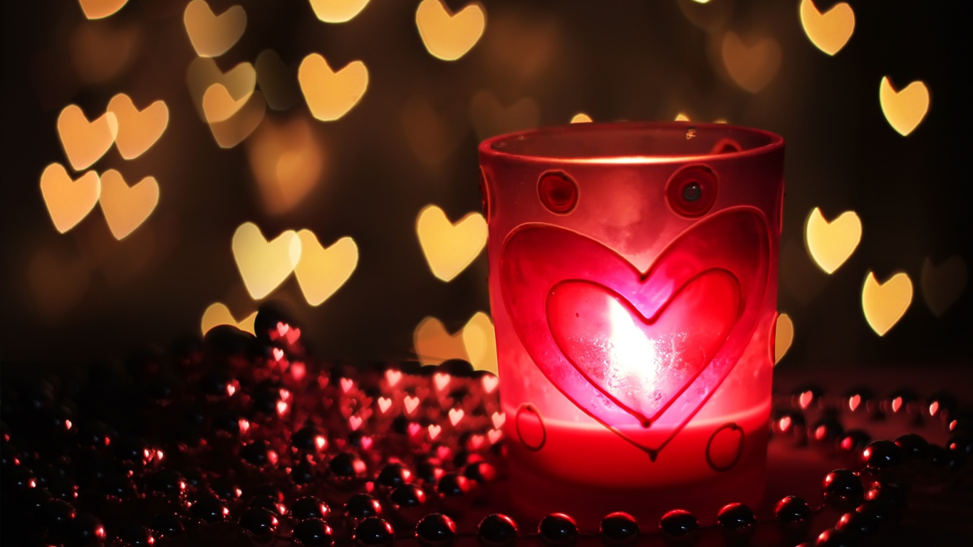 Зажженная свеча на столе с бусами 