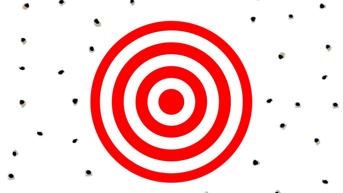 Красная мишень на белом фоне с дырками от пуль