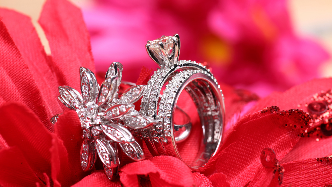 Два кольца с камнями лежат на цветке 